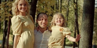 快乐的一家人在秋天的公园里合影