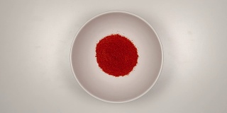 顶视图:红辣椒粉填满一个白色的盘子-停止运动