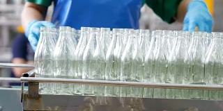 在工厂生产饮用水和饮料。玻璃瓶装药草饮料。