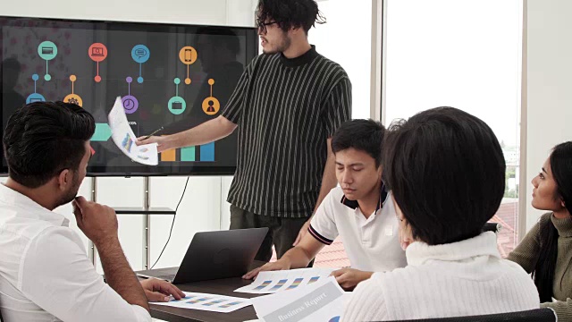 4K商人在商务会议上做演示。创意商务团队会议在现代玻璃办公室，多民族的人在电脑屏幕上工作的组合团队项目