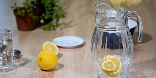 在一个轻便的厨房里，用玻璃瓶准备柠檬和薄荷制成的柠檬汁。