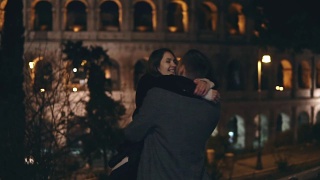 缓慢的运动。一对幸福的年轻情侣在意大利罗马斗牛场附近相遇，拥抱、旋转、亲吻视频素材模板下载