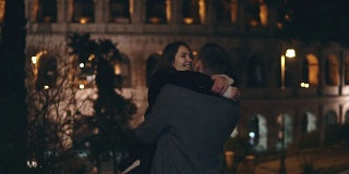 缓慢的运动。一对幸福的年轻情侣在意大利罗马斗牛场附近相遇，拥抱、旋转、亲吻