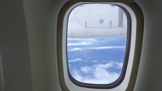 在飞机上透过窗座观看多云的蓝天。视频素材模板下载