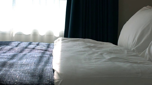 在美丽的卧室里，用干净的白色枕头和床单装饰床。