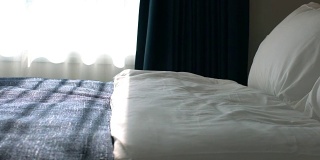 在美丽的卧室里，用干净的白色枕头和床单装饰床。