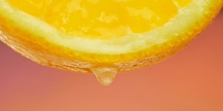 橙汁从一片橘子上滴下的一滴纯净水或果汁