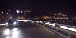 晚上在河边的城市里开车。