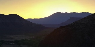 太阳在维珍河谷背后的山脉，犹他州-无人机拍摄
