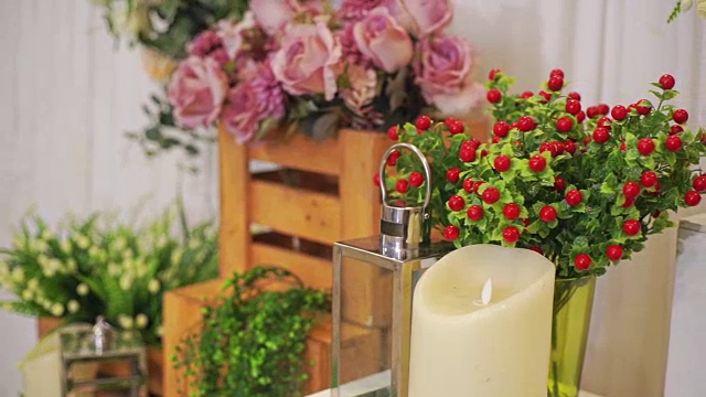 婚礼装饰，桌上有一束人造花和蜡烛。