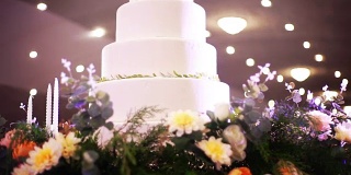 美丽的婚礼蛋糕装饰鲜花和蜡烛在婚宴上。