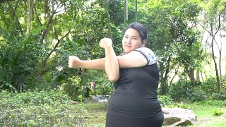 超重的亚洲妇女在公园练习运动视频素材模板下载