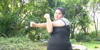 超重的亚洲妇女在公园练习运动