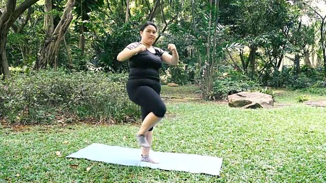 超重的亚洲妇女在公园练习运动