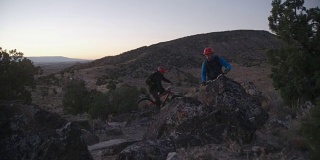 两个骑山地车的人在沙漠的一座山上