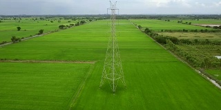 无人机在绿色农场的塔-电塔周围飞行