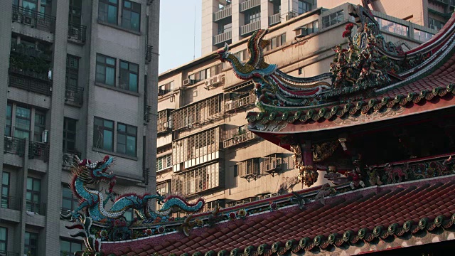 以现代建筑为背景的龙山寺屋顶装饰雕塑