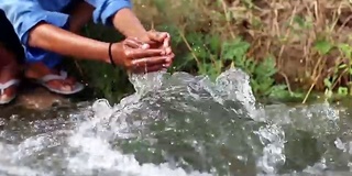 男孩在流动的水中洗手和洗脚