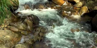湍急的水流在岩石河在山区近距离。山河水流湍急。美丽的风景，野生的自然