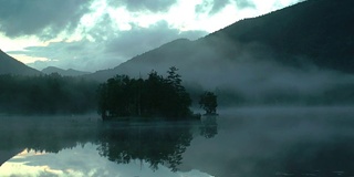 壮丽的全景，美丽宁静的山湖，小岛上的湖被薄雾包围。