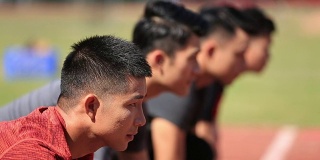 年轻的亚洲成年短跑运动员在起跑线上