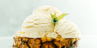 将菠萝和冰淇淋切成薄片，在上面点缀新鲜的薄荷