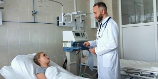 医生站在病床边与年轻的女病人讨论