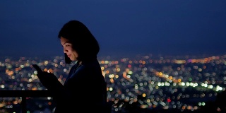 女人用智能手机与城市灯光散景，圈光背景