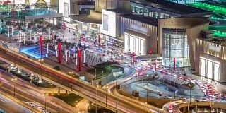 迪拜市中心夜晚的时间推移和道路交通靠近购物中心入口，阿联酋