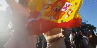 西班牙球迷拿着国旗跳起来庆祝国家足球队的胜利
