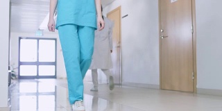 由三名护士和医生组成的团队走过医院走廊。专业人士拯救生命。