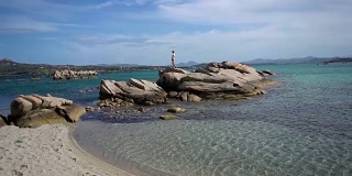 撒丁岛的海岸线和一个年轻女人在偏远的海滩上