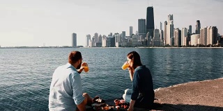 在美国芝加哥密歇根湖畔的浪漫约会。一对美丽的夫妇一起享受野餐