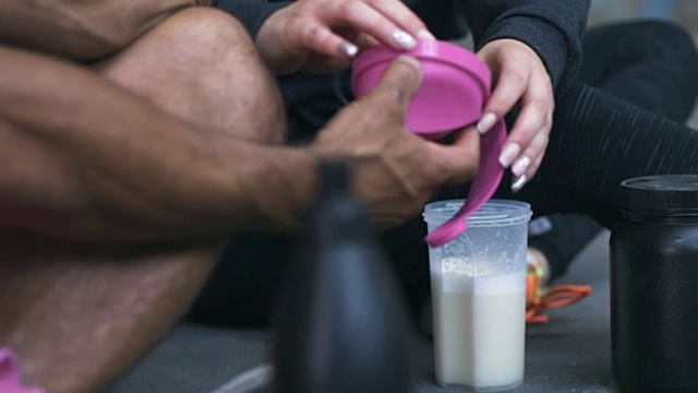 男人和女人在运动后做蛋白质奶昔