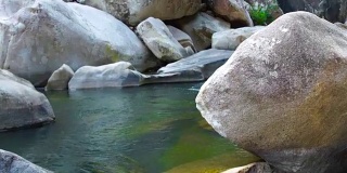 透明而清澈的水在石头河在山。热带雨林中一条平静的河流的光滑表面。河床上的石头。野生自然景观