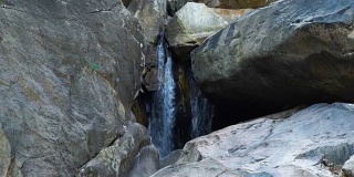 丛林中的高山瀑布。从瀑布中流下的水在河中的巨石上流动。在瀑布瀑布中流过山河。自然景观