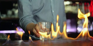 年轻的调酒师正在烧制酷酷的鸡尾酒。
