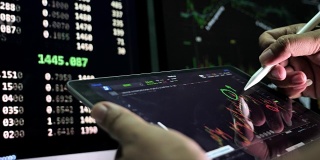 商人使用平板电脑分析股票市场