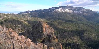 无人机俯瞰城堡岩石山峰与大雪山在塔霍湖背景，加利福尼亚