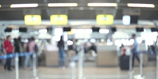 模糊画面显示，国际机场航站楼的乘客走向值机柜台。带有散焦效果的4K视频。
