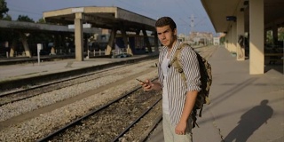 年轻人独自在火车站等待火车