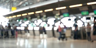 模糊画面显示，国际机场航站楼的乘客走向值机柜台。带有散焦效果的4K视频。