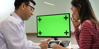 医生与病人在绿屏电脑上讨论结果