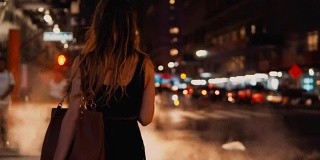 年轻美丽的女人站在人行横道附近的背影，在纽约，美国市中心的交通道路