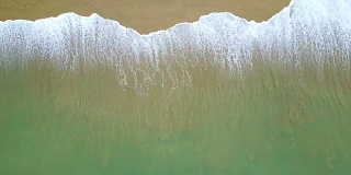 环抱绿松石海浪到达海岸线的鸟瞰图。从俯视图看，美丽的热带海滩。暑假放假概念。