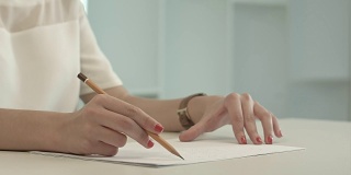 女人用铅笔在纸上写字