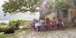 一家人在院子里的树下吃午饭