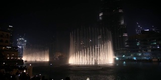 夜城，全景-迪拜舞蹈喷泉。人们观看这个节目。