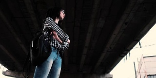 一个伤心的被冒犯的女孩独自站在桥下