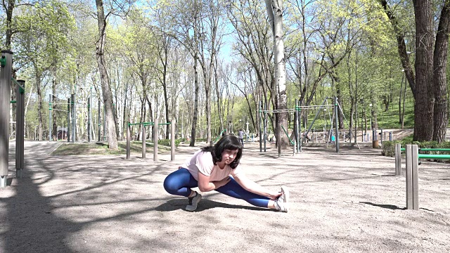 胖女孩在公园里做伸展运动